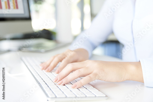 Typing on keyboard. Close-up image of a woman's hands typing on her computer keyboard while sitting at office and working online.