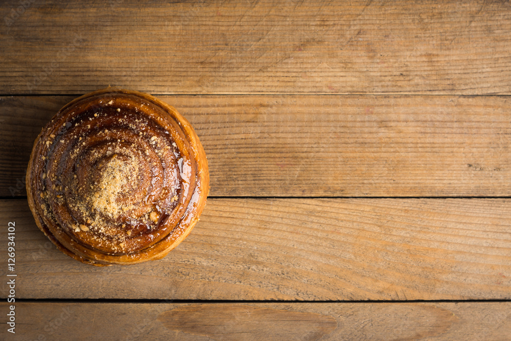 Fresh bun on the rustic wooden background. Selective focus.
