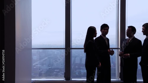 DS MS Senior businessman talking to young business people by window in office / China