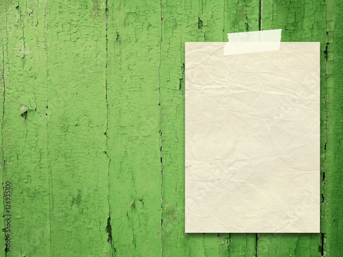 Single blank old paper frame on green wooden boards background