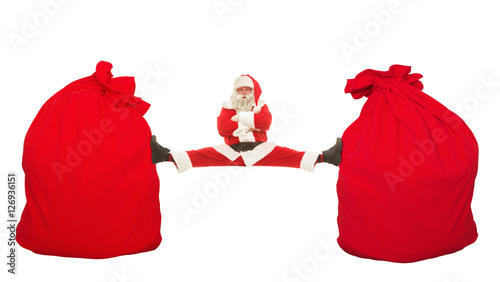 Santa Claus sits on a splits stretching between two mbolshih bag