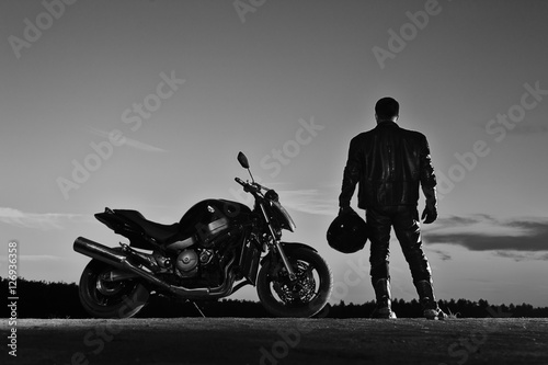 Tela Silhouette of male biker standing next to bike