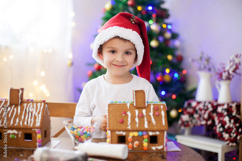 Cute little boy, making gingerbread cookies house for Christmas Cute little boy, making gingerbread cookies house for Christmas