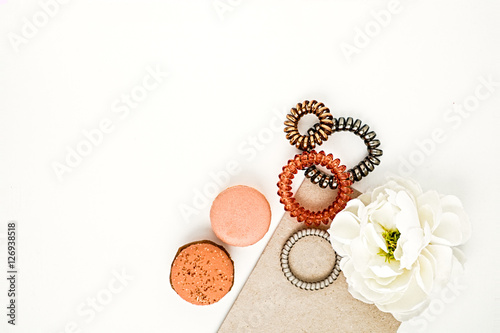 Feminine hair bands, macarons and flower on a white background
