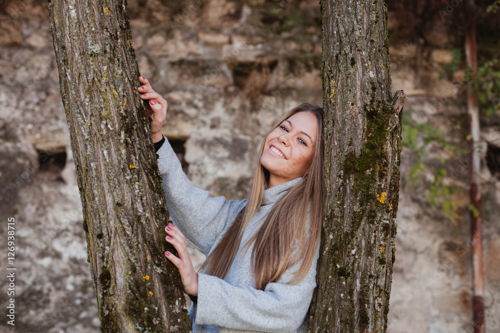 Beautiful woman next to the trunk of a tree Beautiful woman next to the trunk of a tree