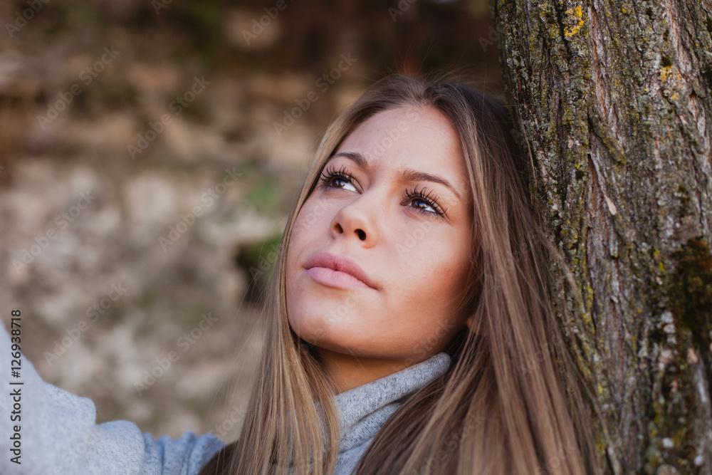 Beautiful woman next to the trunk of a tree Beautiful woman next to the trunk of a tree