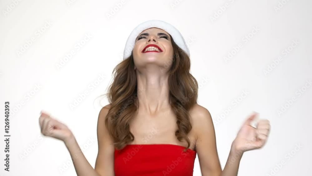 Attractive happy woman in red christmas dress covering eyes with palms and getting present Attractive happy woman in red christmas dress covering eyes with palms and getting present