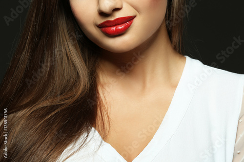 Portrait of beautiful young woman on dark background  close up view