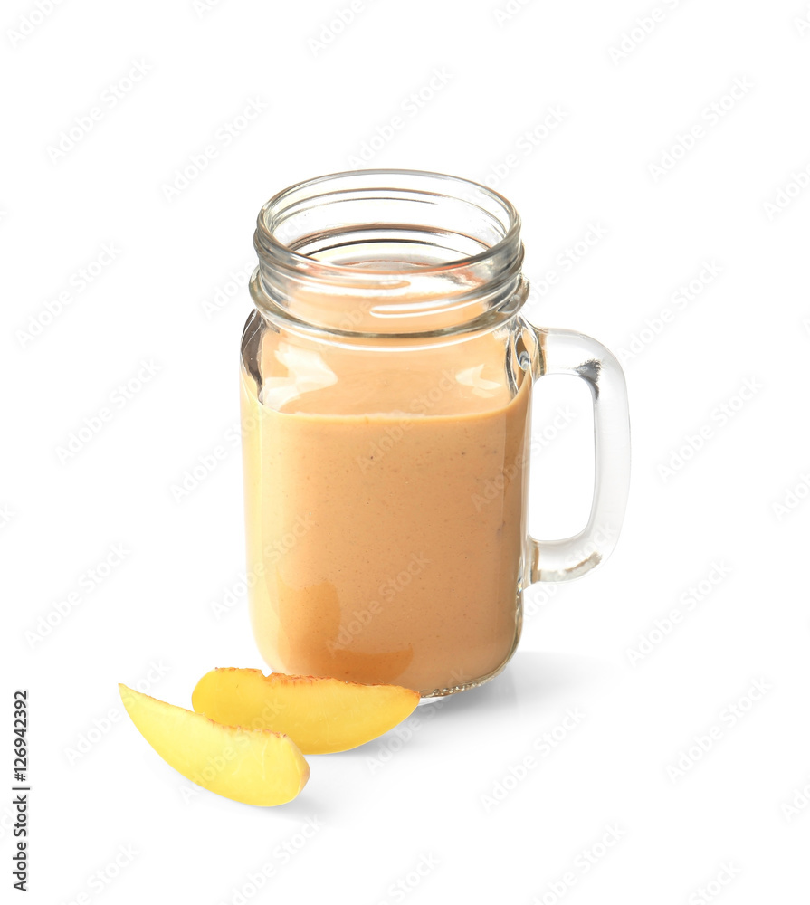 Mason jar with tasty smoothie and peach on light background Mason jar with tasty smoothie and peach on light background