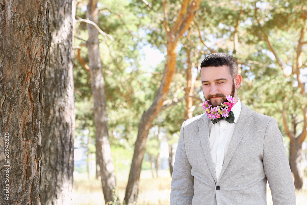 Handsome man with beard of flowers on light background Handsome man with beard of flowers on light background