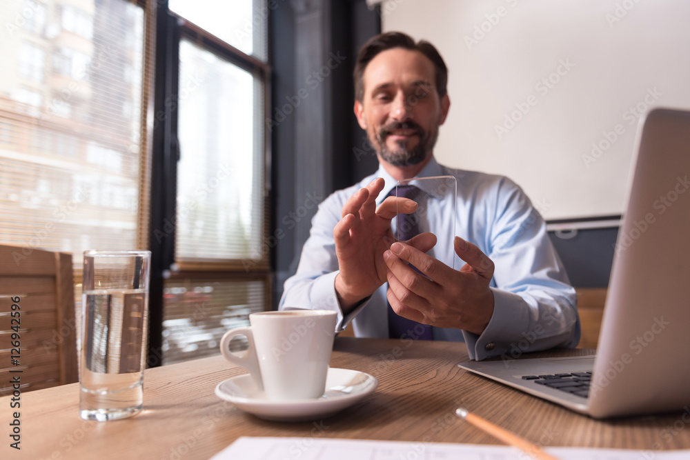 Handsome joyful man holding a cell phone Handsome joyful man holding a cell phone