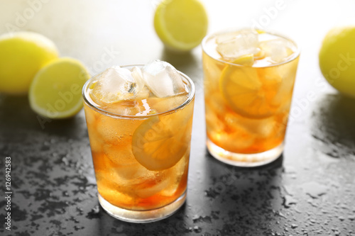 Glasses of iced tea with lemon slices on gray background