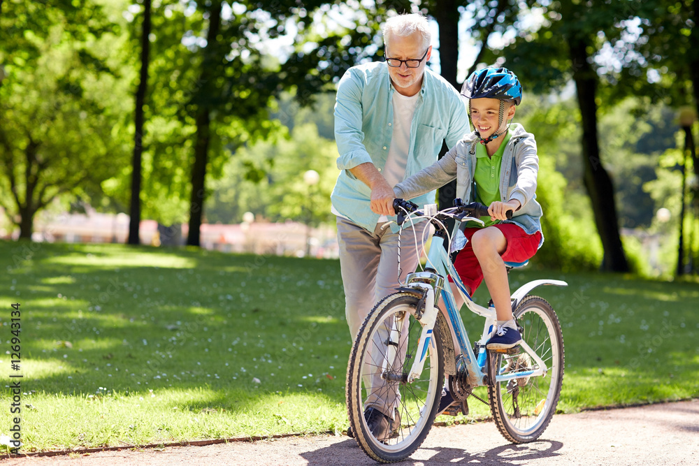grandfather and boy with bicycle at summer park grandfather and boy with bicycle at summer park