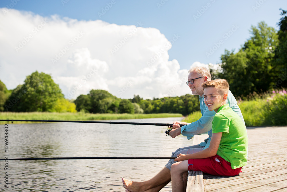 grandfather and grandson fishing on river berth