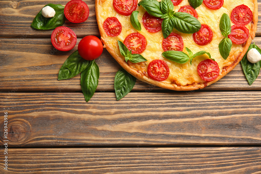 Fresh tasty pizza Margarita and tomatoes on wooden background, top view