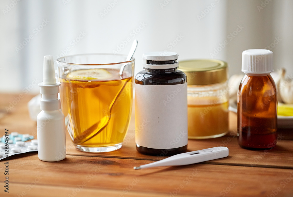 drugs, thermometer, honey and cup of tea on wood drugs, thermometer, honey and cup of tea on wood