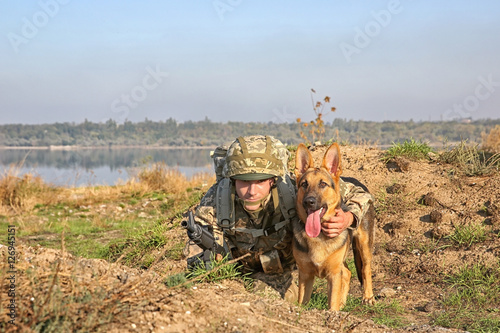 Soldier with german shepherd dog at military firing range