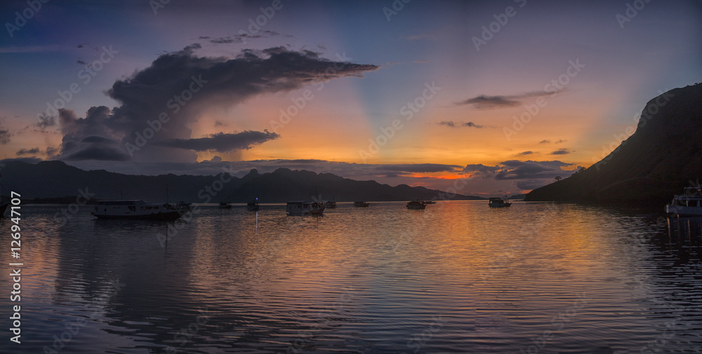magical sunset over sea with some boats at anchor in indonesia
