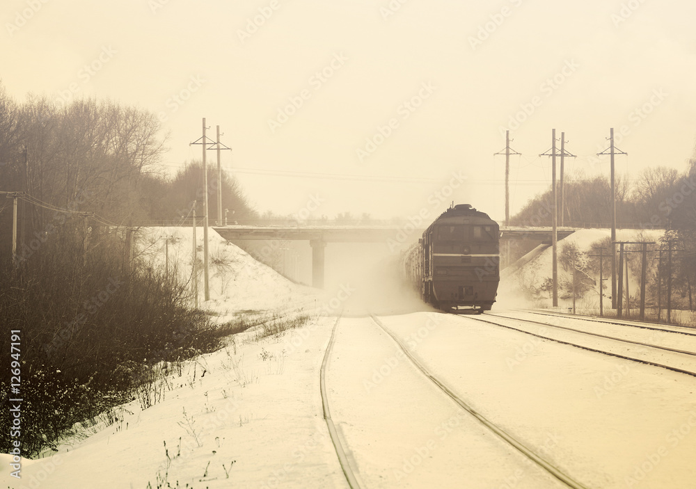 Moving train in snow winter in vintage tones. Winter landscape with train in color sepia