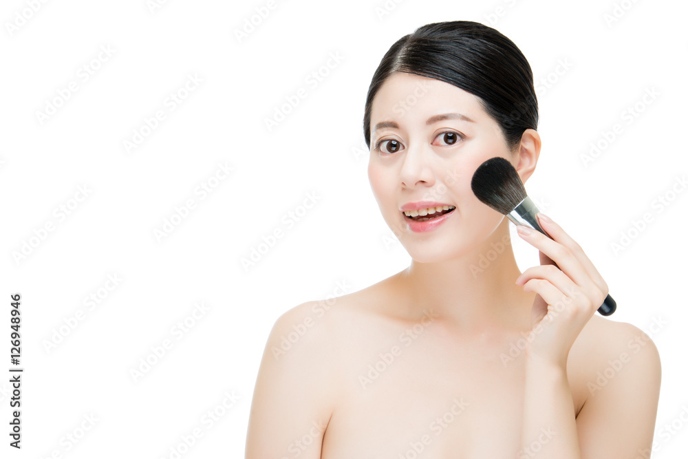 Beautiful young woman applying foundation powder blush with make Beautiful young woman applying foundation powder blush with make