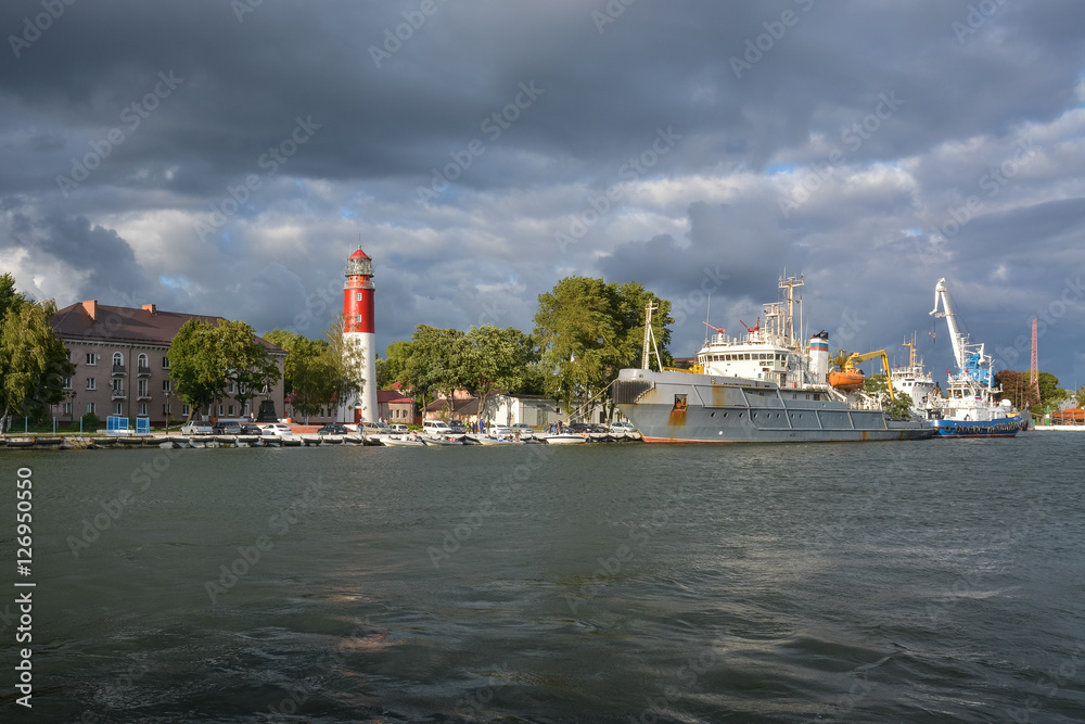 Lighthouse in the seaside town and ships at berth