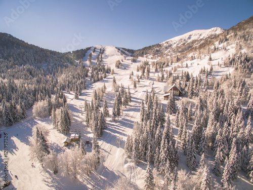 Aerial: People Skiing In A Beautiful Snowy Ski Resort At Winter