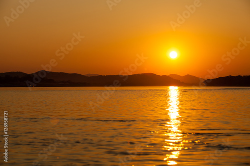Fototapeta Naklejka Na Ścianę i Meble -  Beautiful sunset to the natural river with silhouette mountain in background.