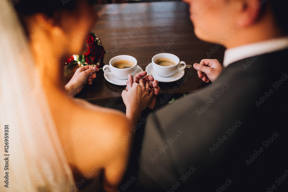 Bride and groom drinking coffee at cafe after their wedding. Posing and embracing newlyweds. Bride and groom drinking coffee at cafe after their wedding. Posing and embracing newlyweds.