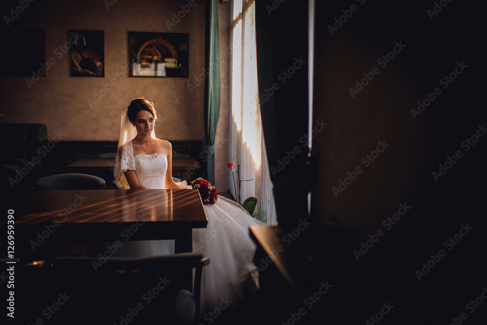 Elegant beautiful wedding bride posing near great window arch Elegant beautiful wedding bride posing near great window arch