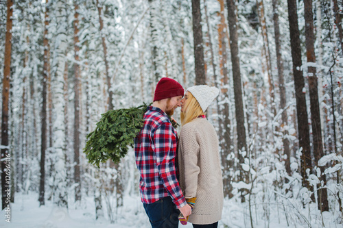 young couple with fir twigs walk in the winter woods © frizza