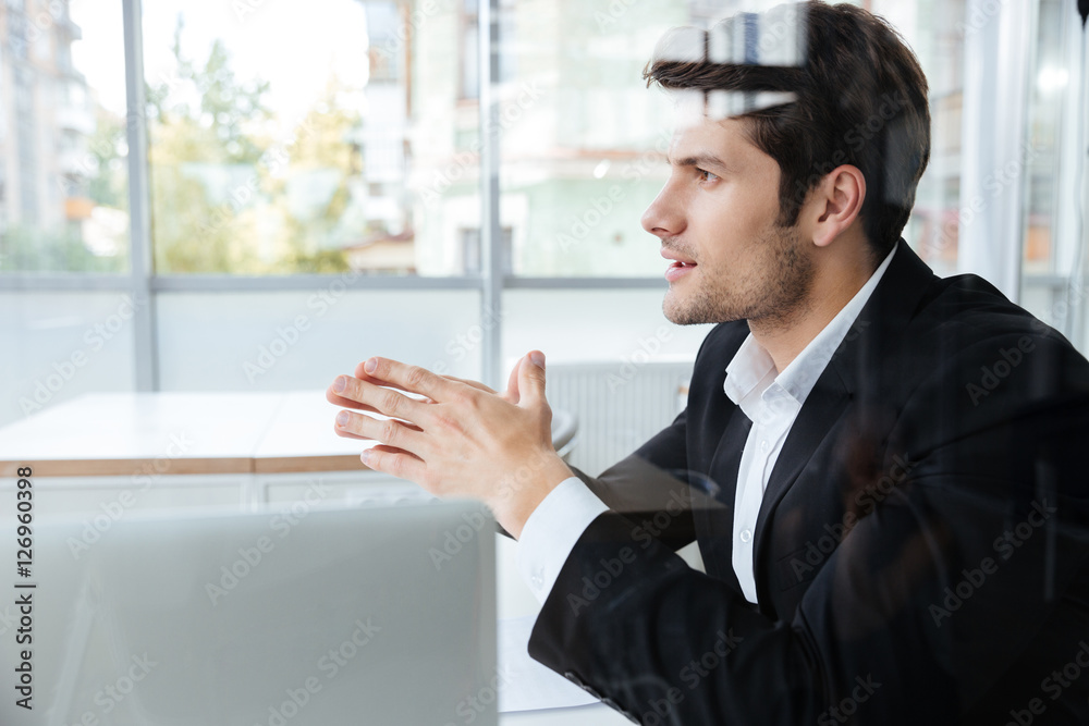Fototapeta premium Businessman in black suit sitting in office