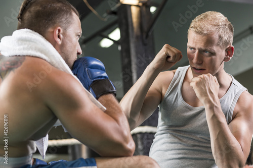 Fototapeta Naklejka Na Ścianę i Meble -  Trainer motivating boxer during fight