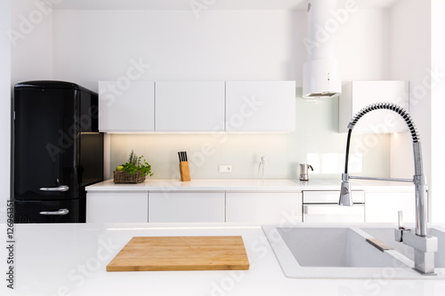 White, lacquer kitchen and black retro fridge