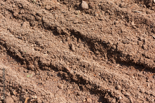 Brown dry plowed soil surface with grooves