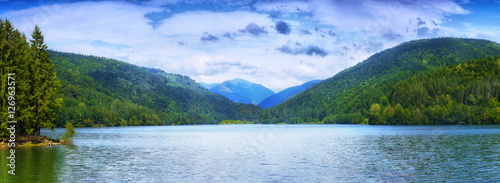 Panoramic view of beautiful lake and spruce forest in mountains