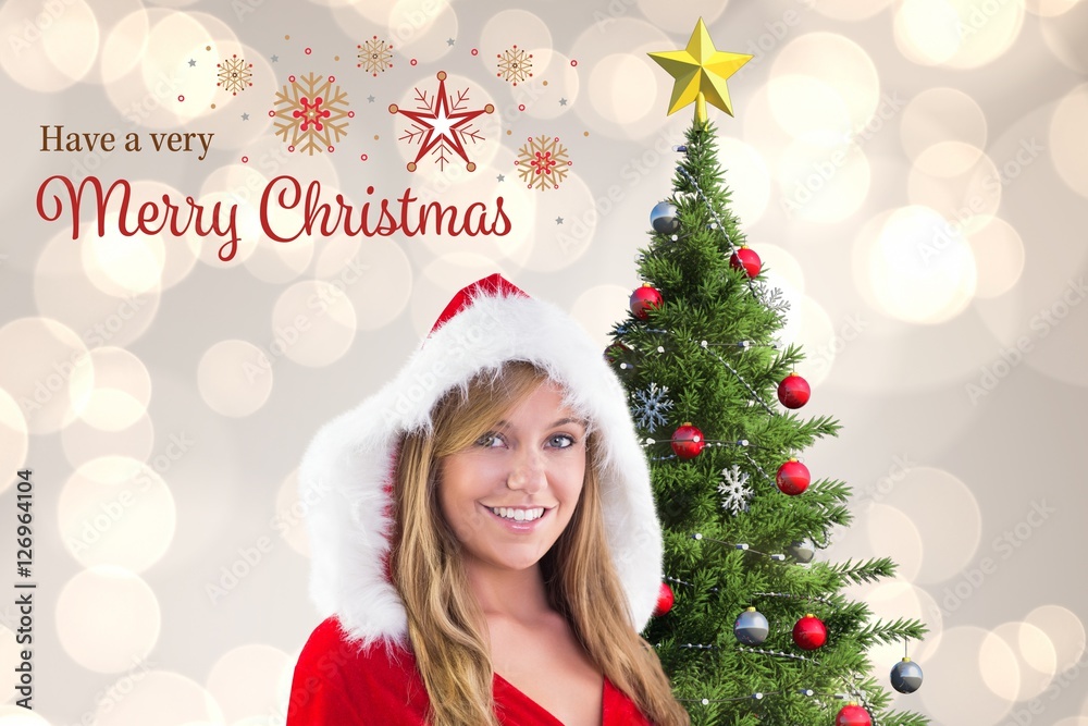 Beautiful woman in santa costume standing near christmas tree Beautiful woman in santa costume standing near christmas tree