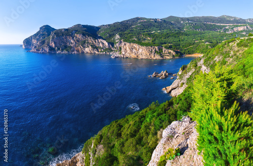Landscape of Paleokastritsa famous beach in close bay with crystal clear azure water on Corfu island, Ionian archipelago, Greece.