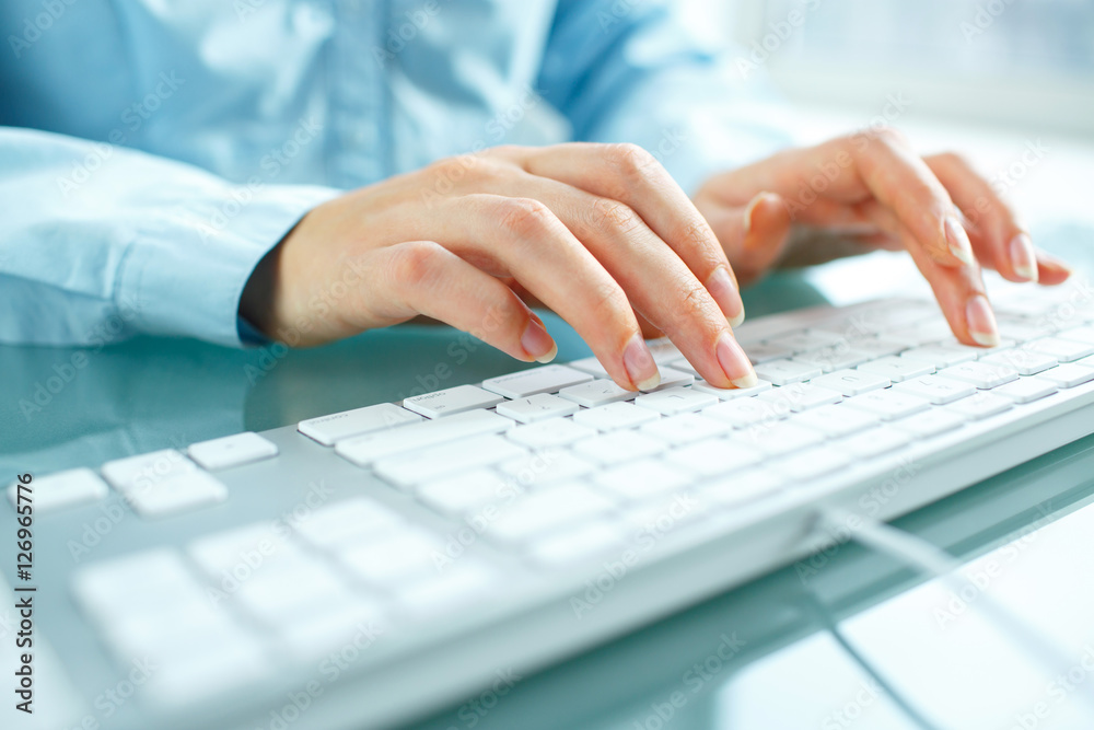 Woman office worker typing on the keyboard