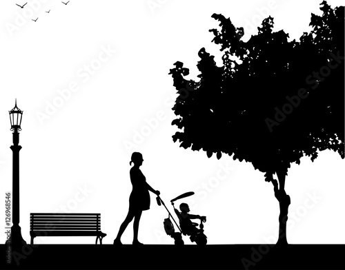 Pregnant woman walking with baby on a tricycle in park, one in the series of similar images silhouette