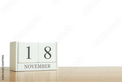 Closeup surface white wooden calendar with black 18 november word on blurred brown wood desk isolated on white background with copy space , selective focus at the calendar
