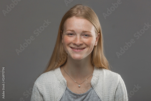 red-haired girl close up on a gray background