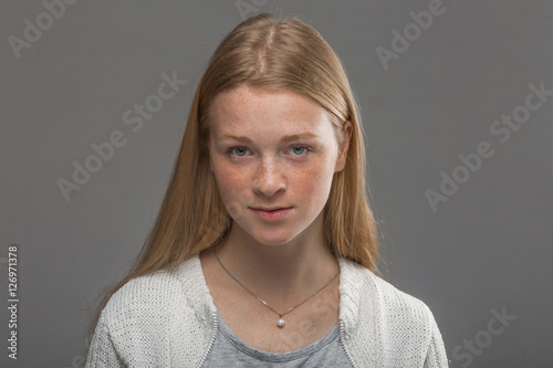 red-haired girl close up on a gray background