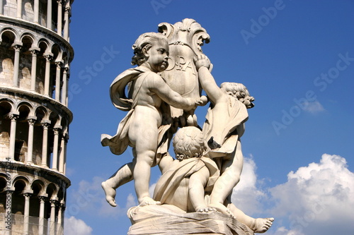 Engelsstatue mit Wappenschild und Inschrift vor schiefem Turm in Pisa