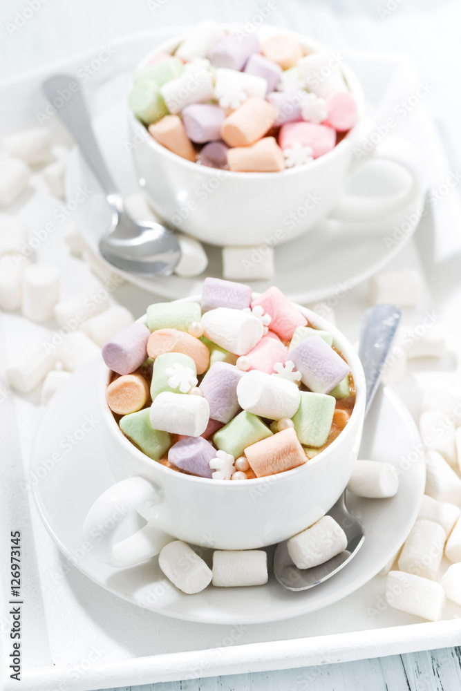 cocoa with colorful marshmallow in white cups, vertical top view cocoa with colorful marshmallow in white cups, vertical top view