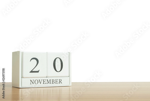 Closeup surface white wooden calendar with black 20 november word on blurred brown wood desk isolated on white background with copy space , selective focus at the calendar