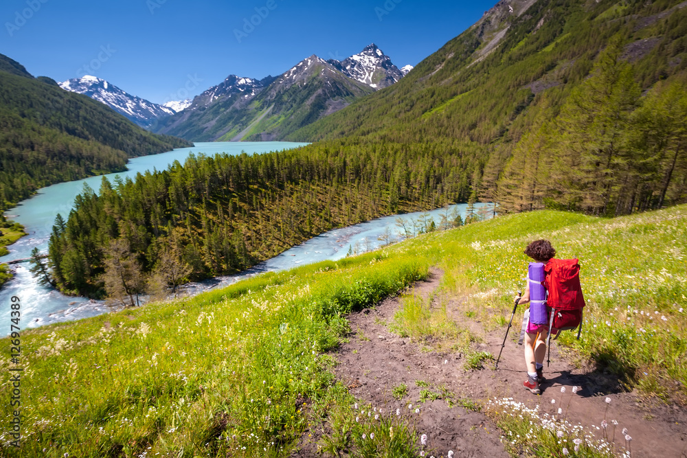 Woman hike with backpack at the lake of highlands of Altai mount