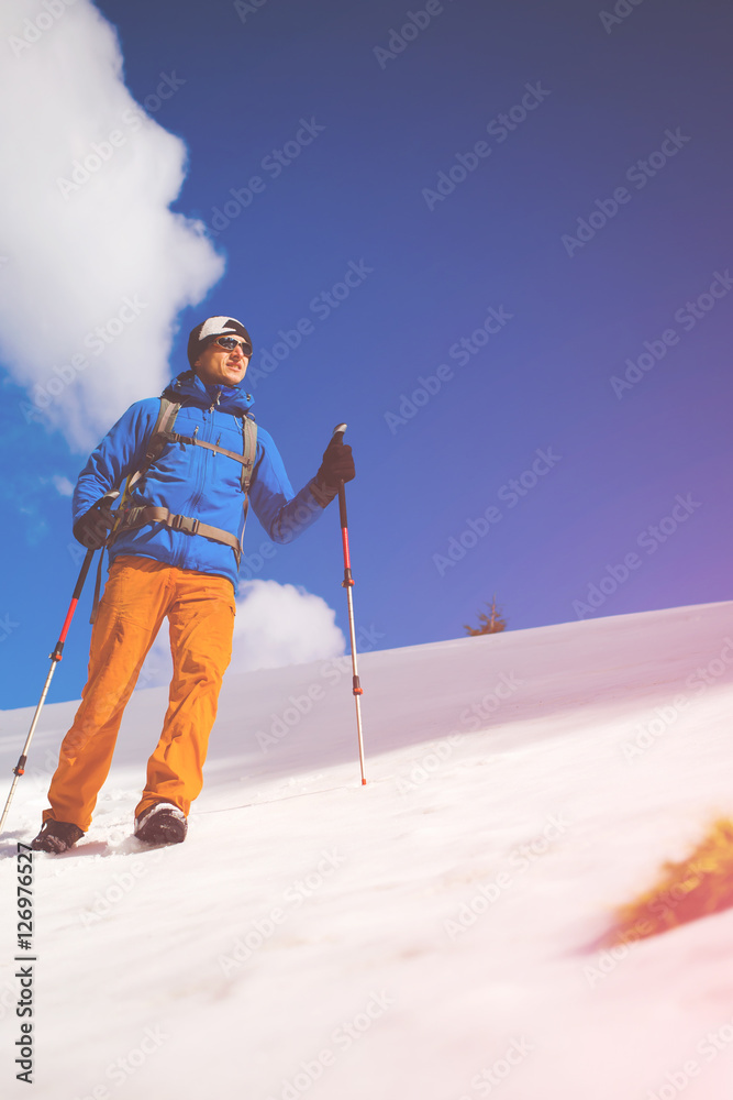 Mountain climber walks on a snowy slope.
