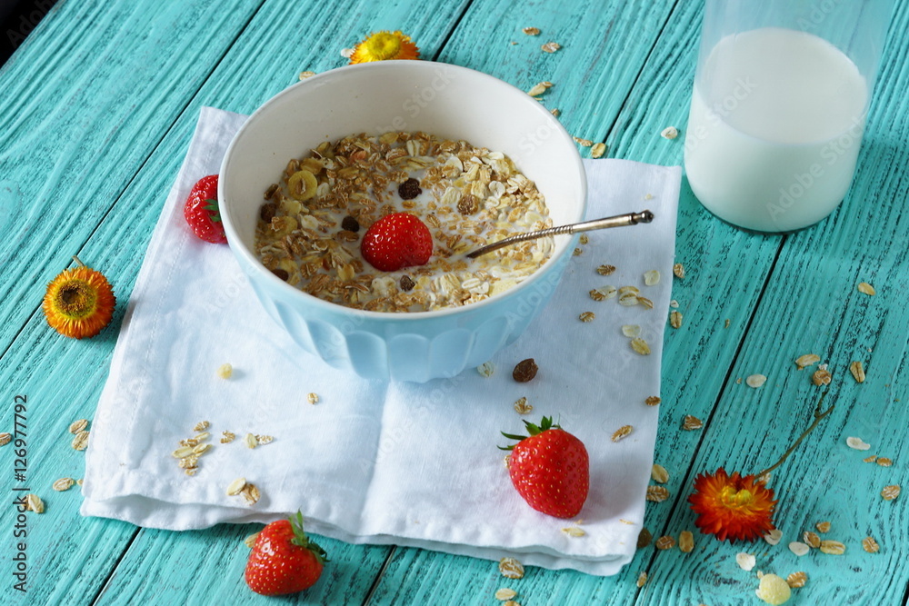 Breakfast for the good health of the cereals with strawberries and milk on a light green background Breakfast for the good health of the cereals with strawberries and milk on a light green background