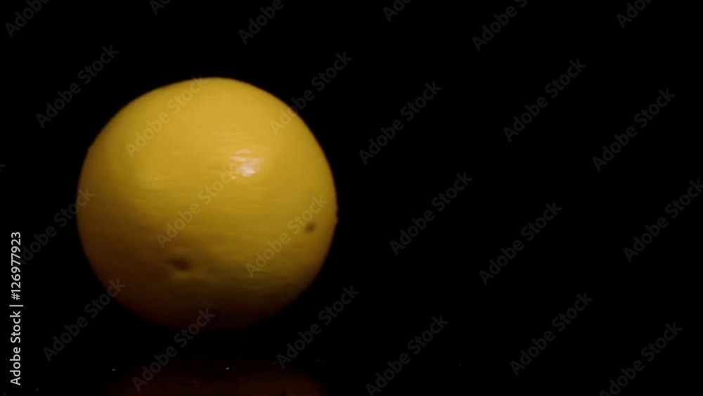Spinning orange on the ground in slow motion Spinning orange on the ground in slow motion