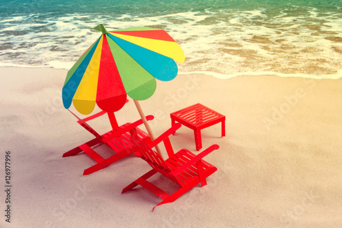 Pair of sun loungers and a beach umbrella on a deserted beach